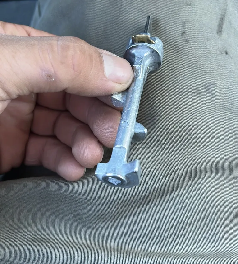 A mechanic holds an ignition lock part removed during a mobile mechanic repair